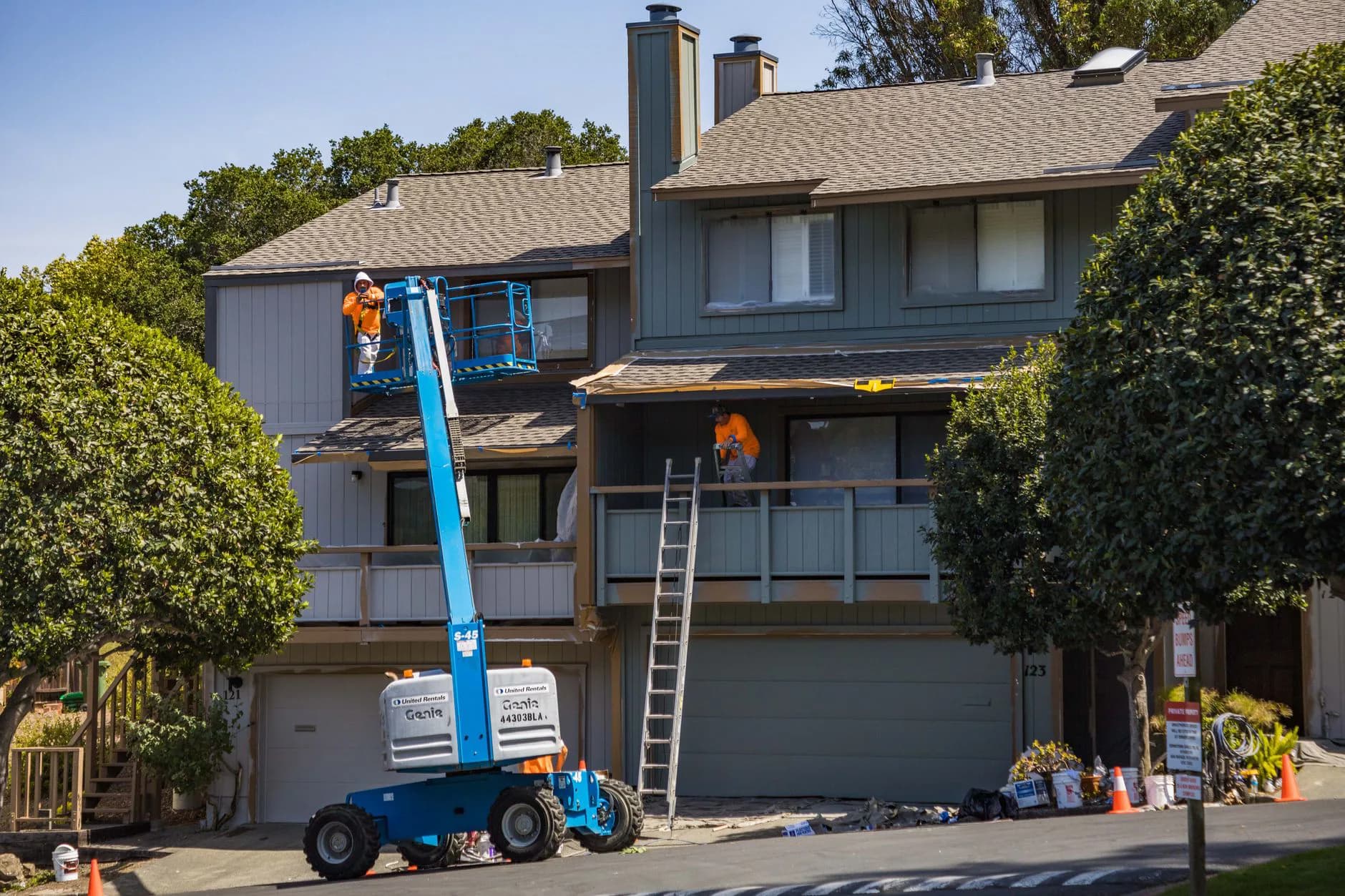 Installers hanging siding across the exterior wall of a house