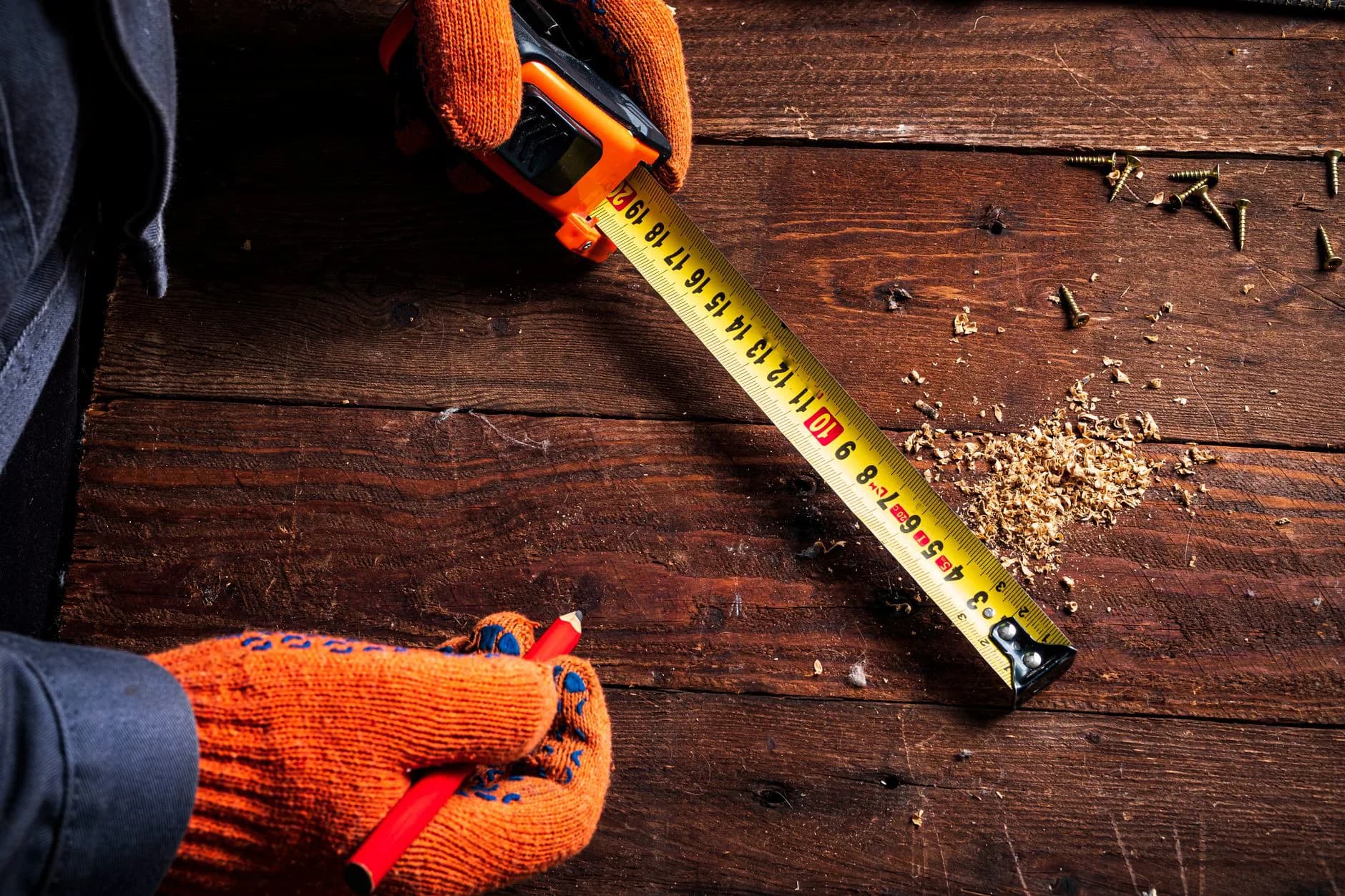 A worker measuring on a roof