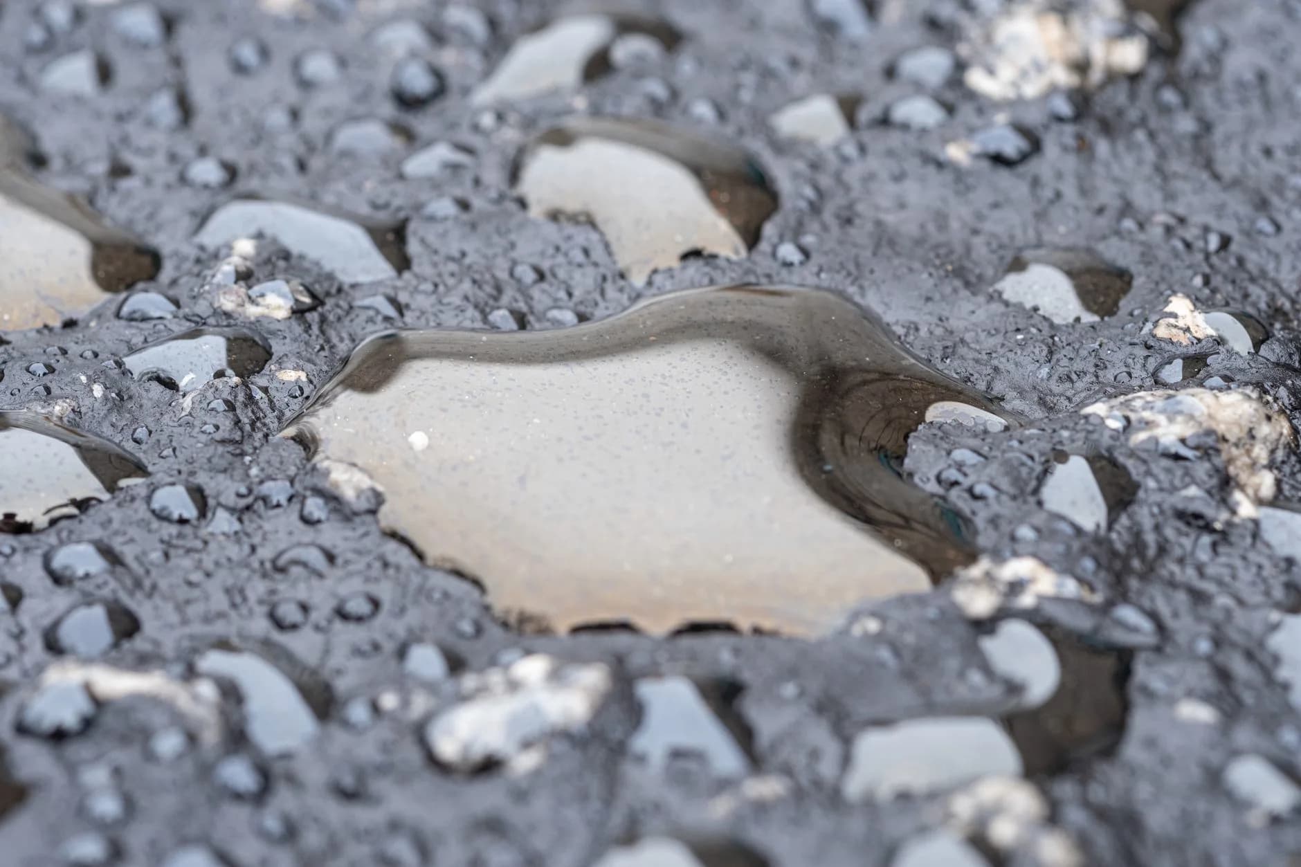 Water standing in puddles across a flat surface