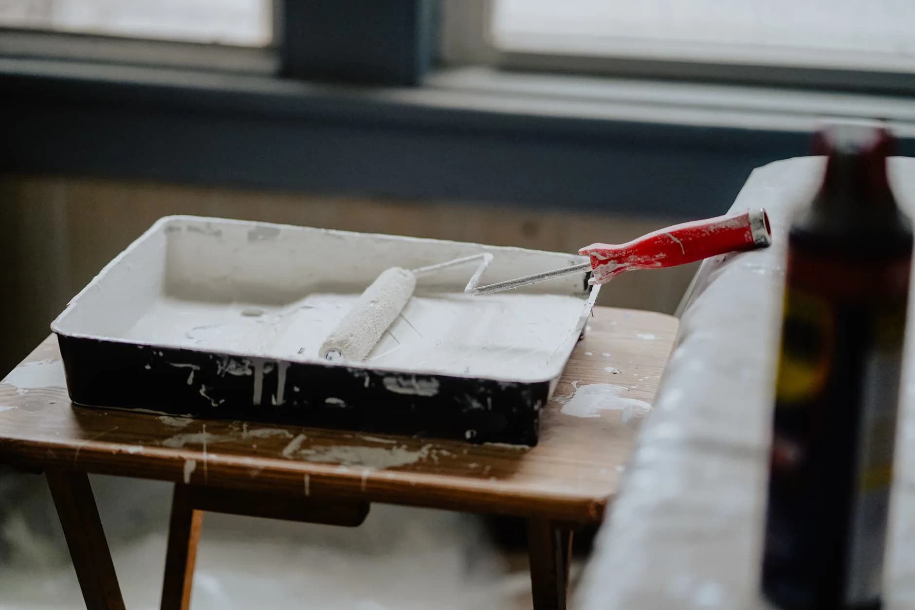 A paint roller and tray on a bench during a renovation