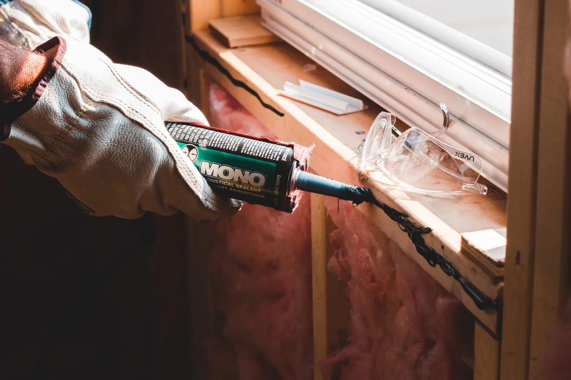 A caulking gun being used on a joint