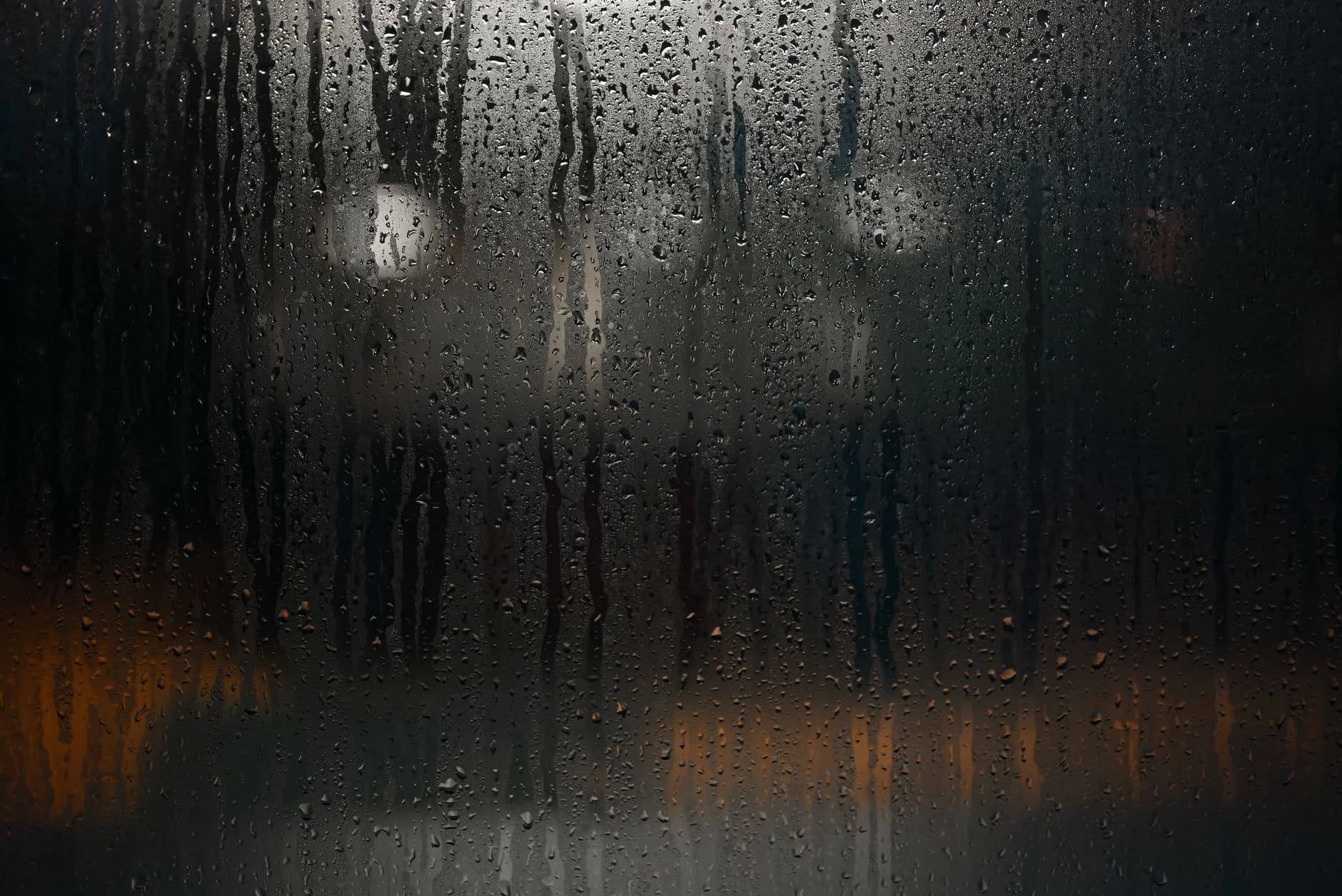 Rain running down a window at night