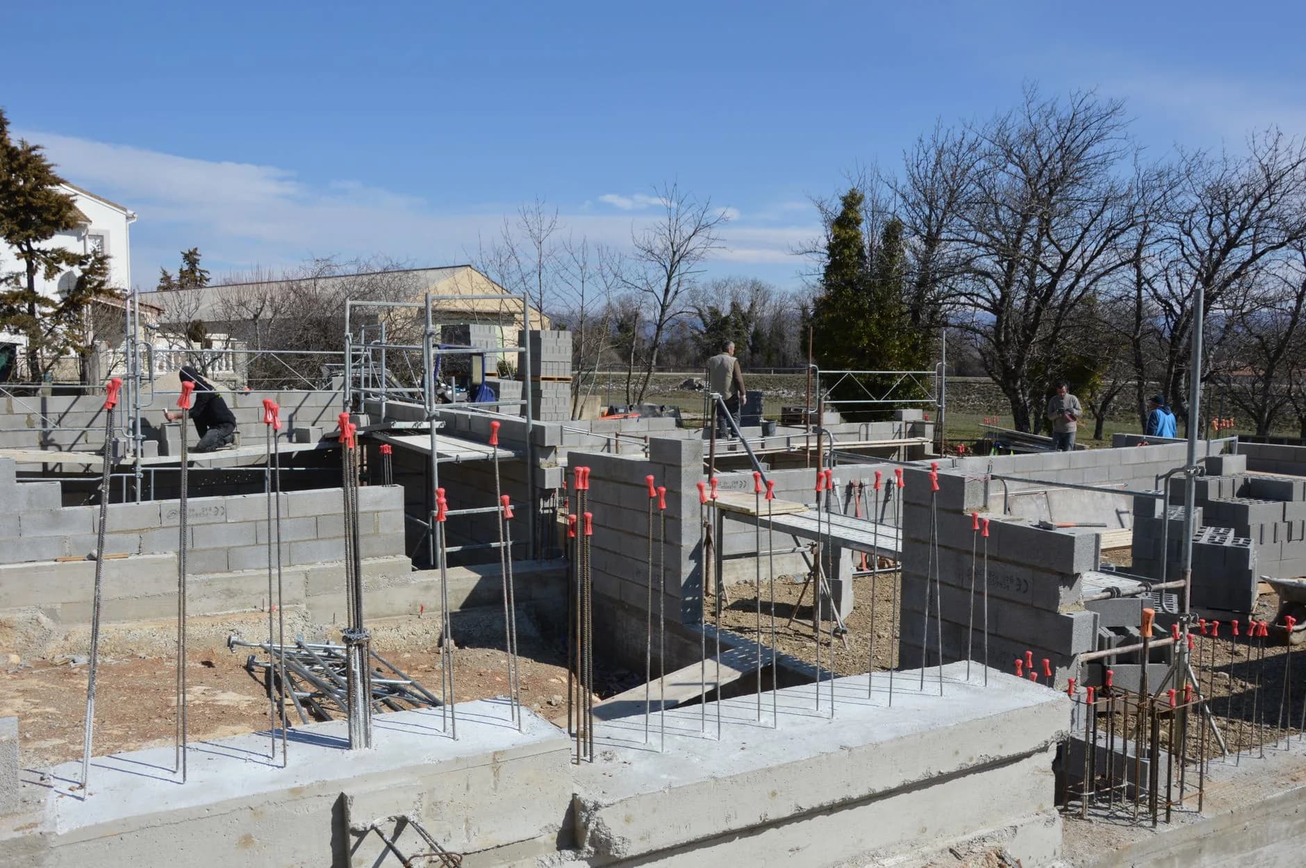 Workers on a poured concrete foundation at a construction site