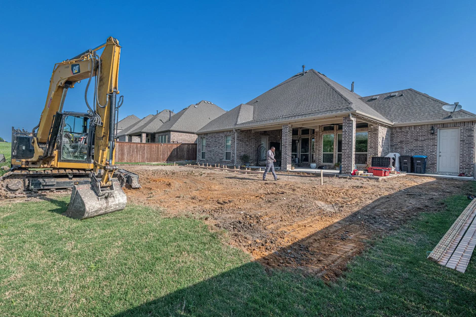 Heavy machinery working in the back garden of a house