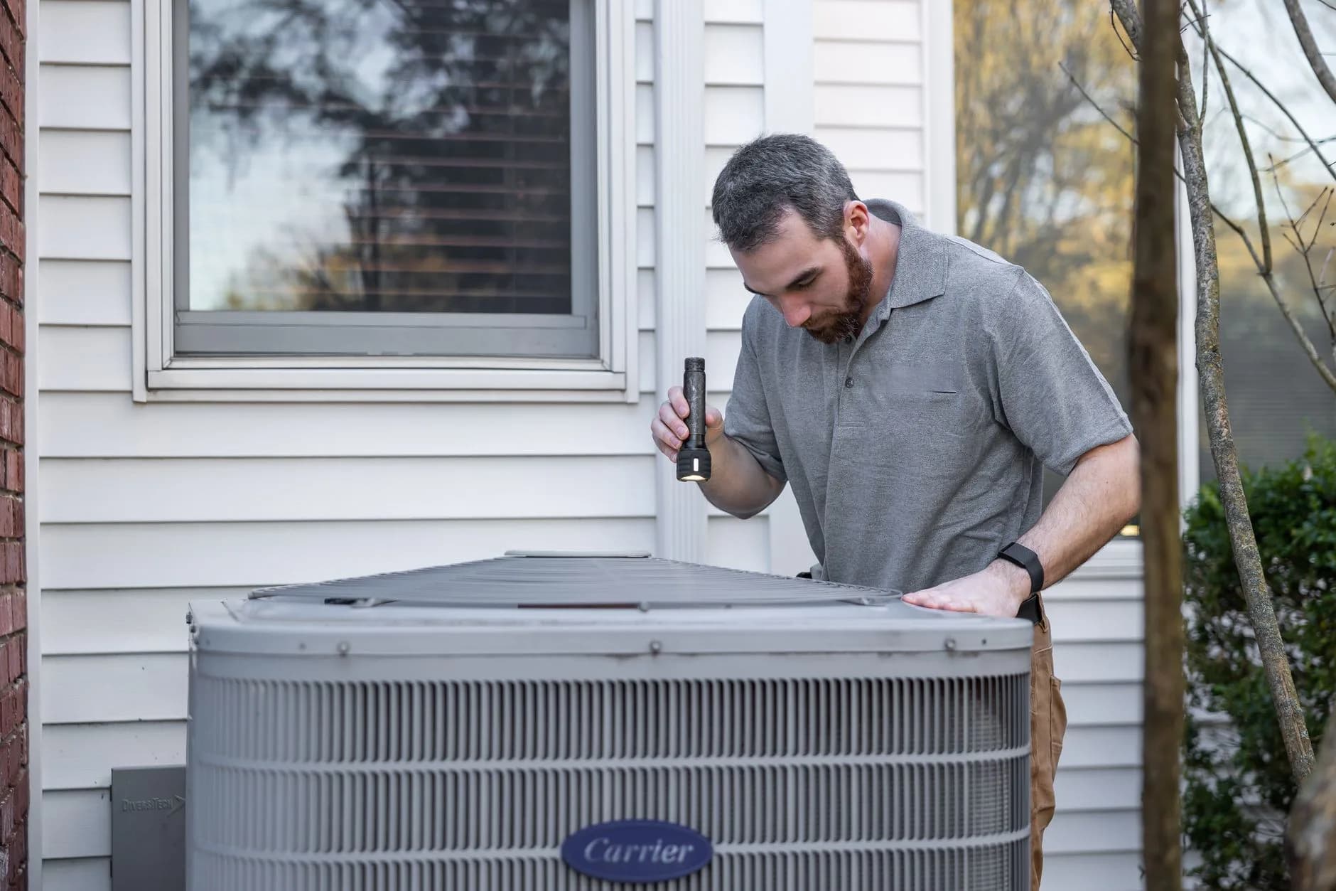 An HVAC technician connecting a newly installed condenser unit