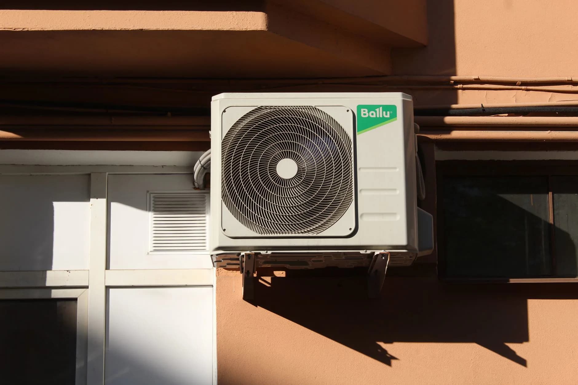 An outdoor air conditioning condenser beside a house