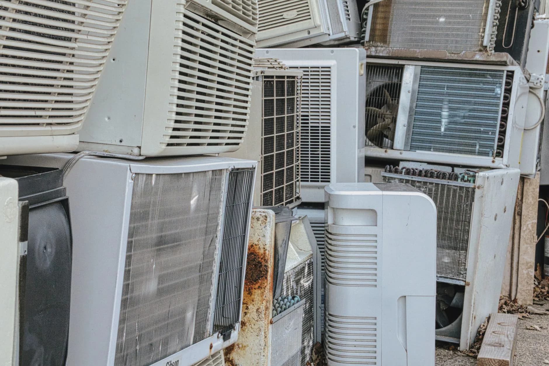 Discarded air conditioning units stacked outdoors