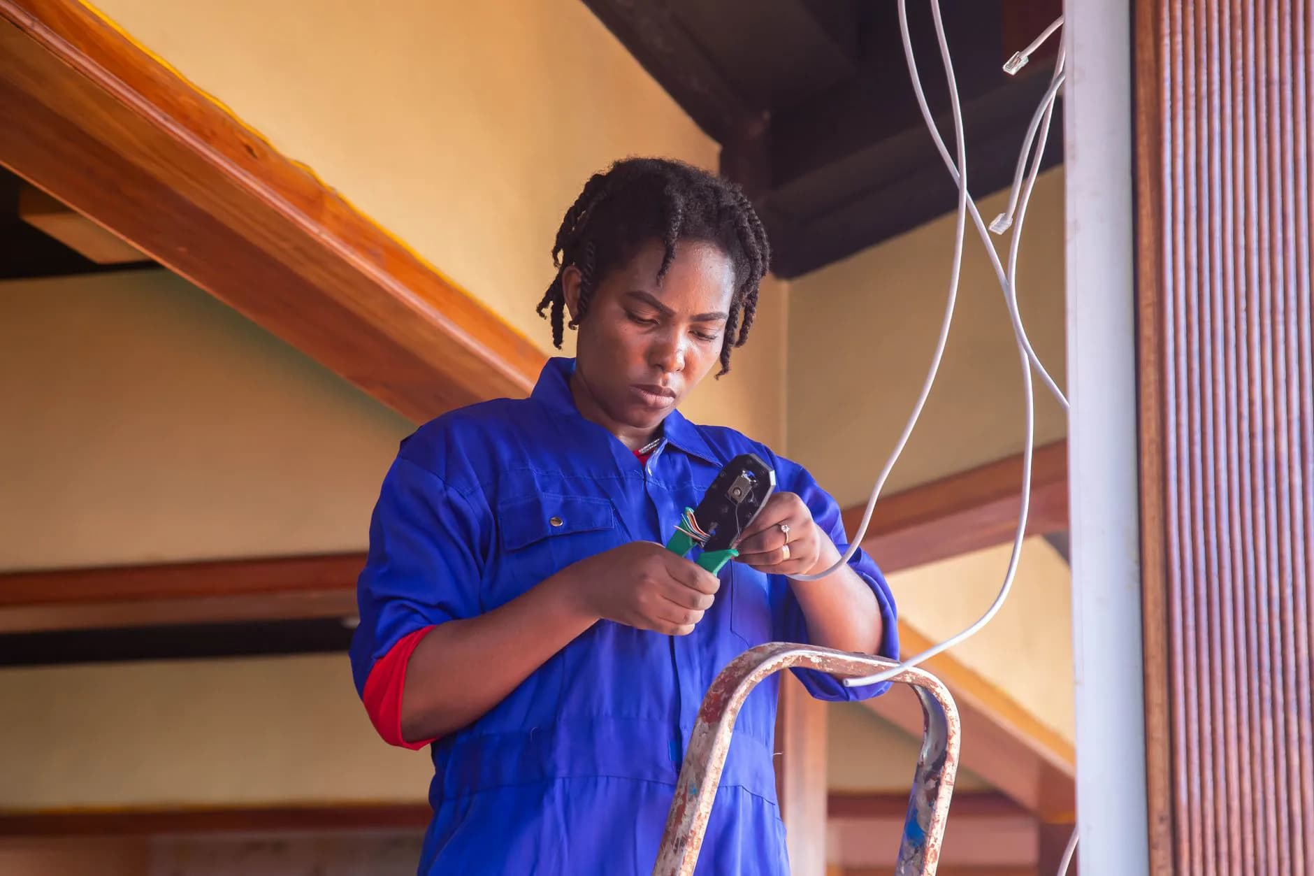 A technician working from a ladder indoors