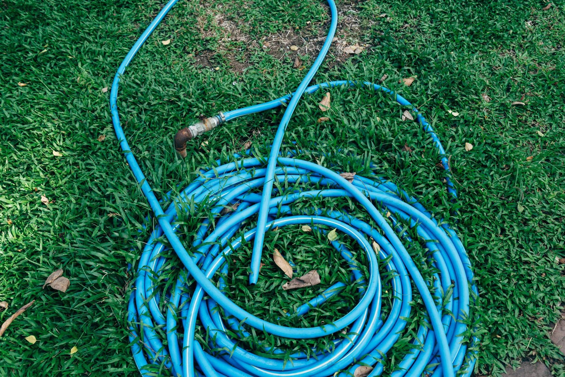 A garden hose connected to an outside tap