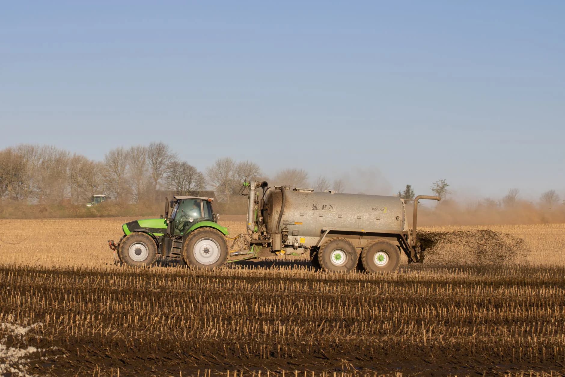 Green hydroseed slurry sprayed over bare soil