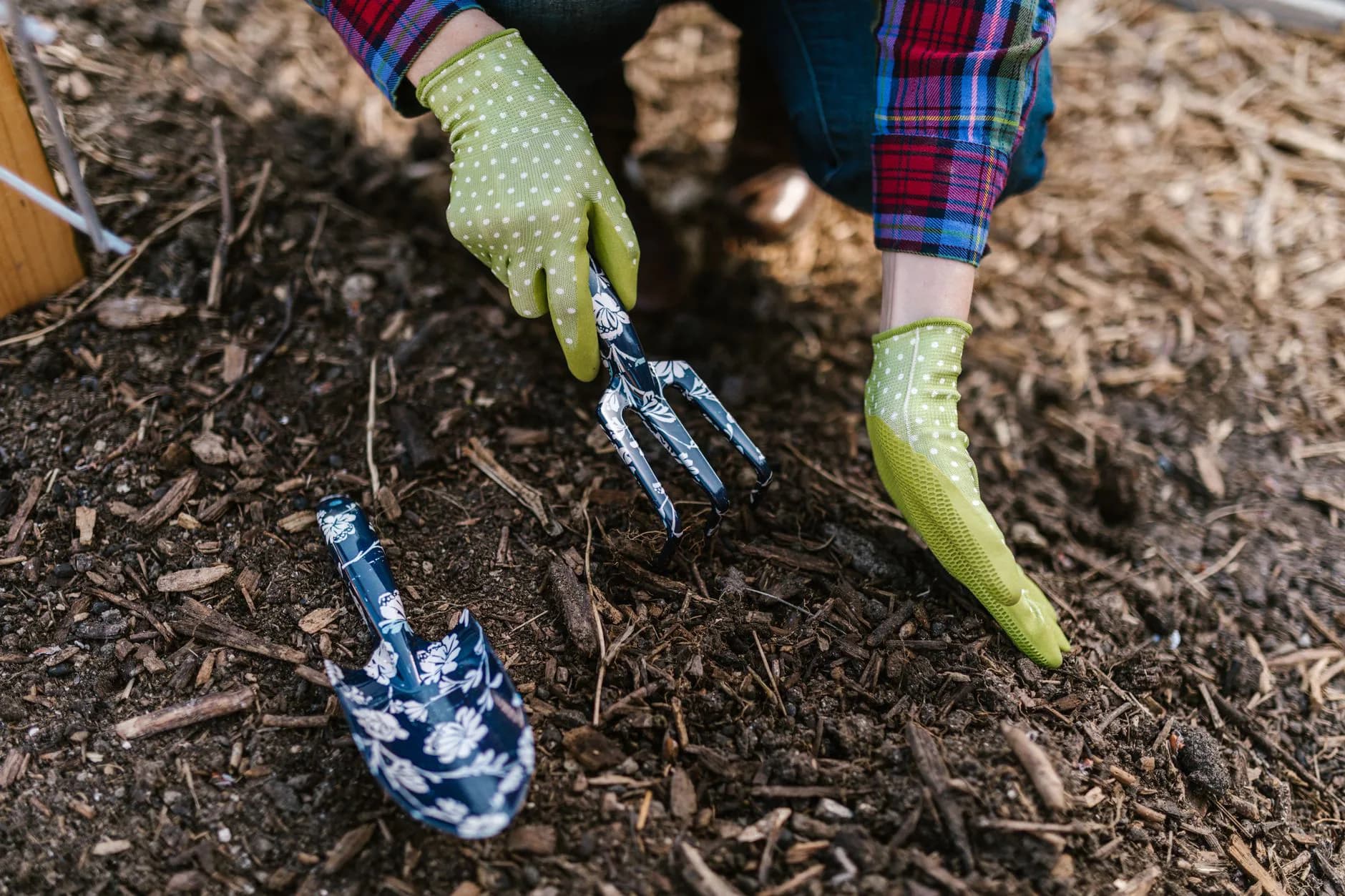 Mulch being raked into a planting bed