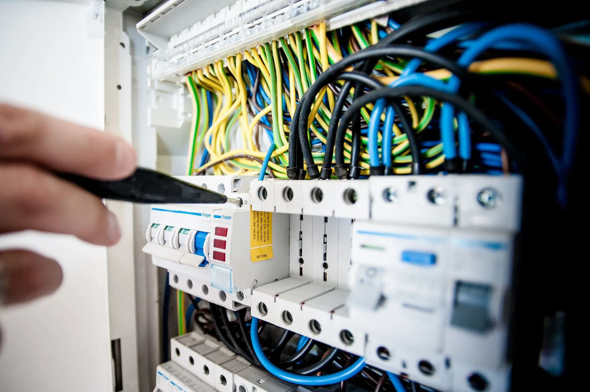 An electrician landing circuit wires on new breakers in an open panel