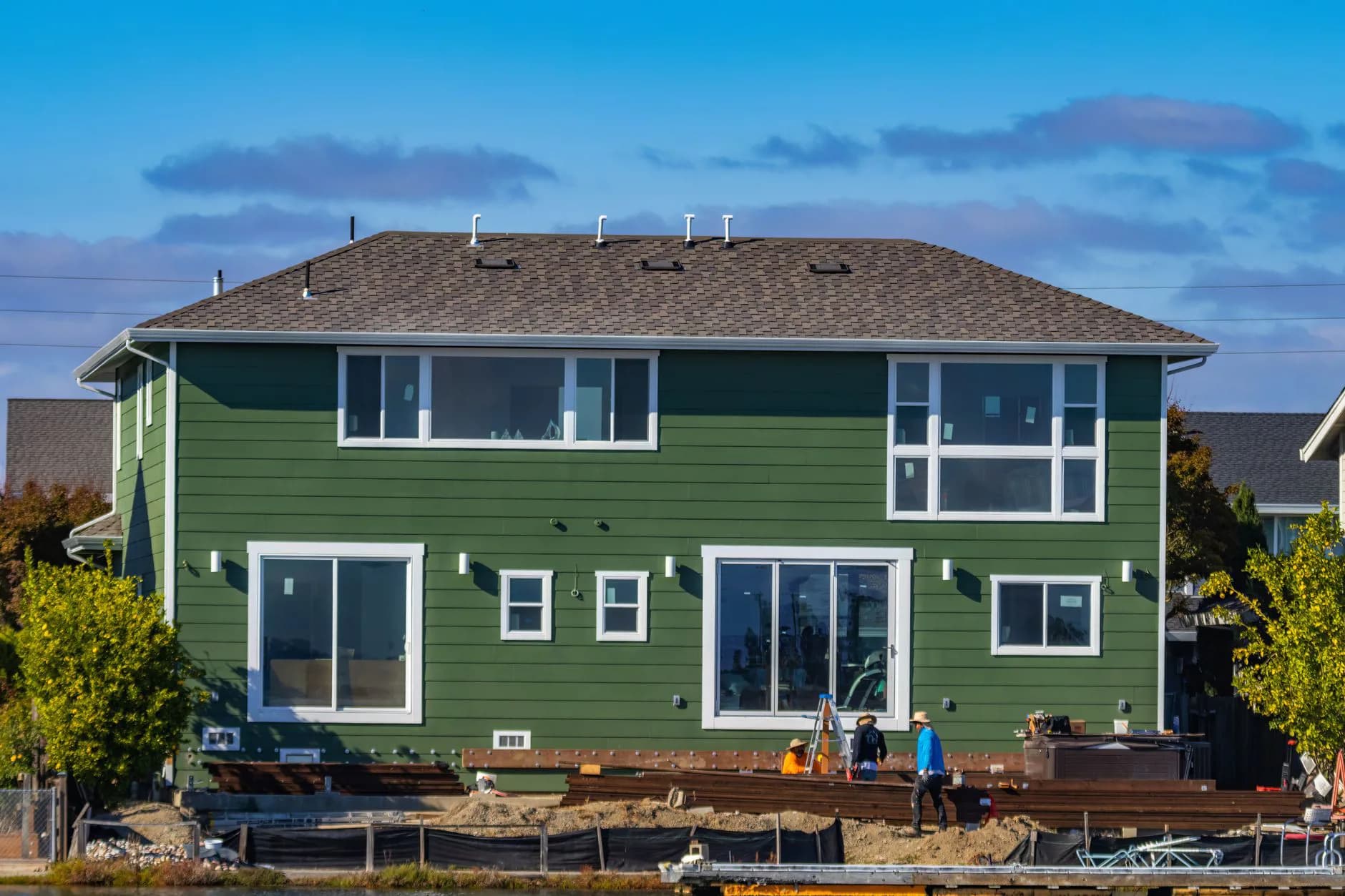 A worker fastening siding panels to a house wall