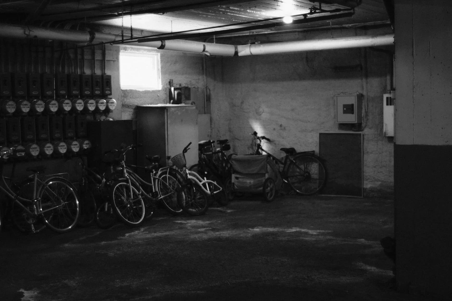 A deep-cycle battery in a plastic battery box on a basement floor