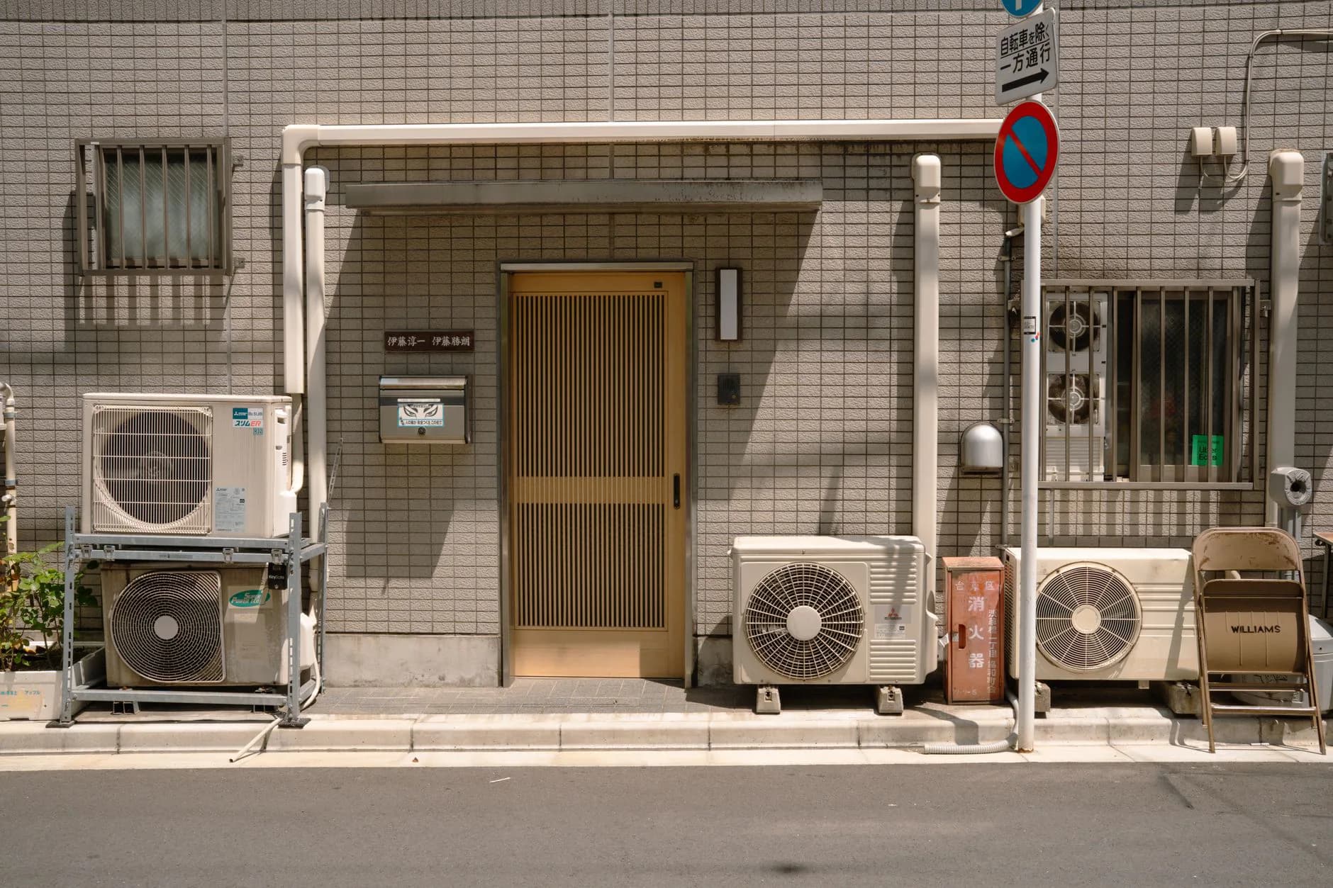 A heat pump outdoor unit beside a house with insulated refrigerant lines running up the wall