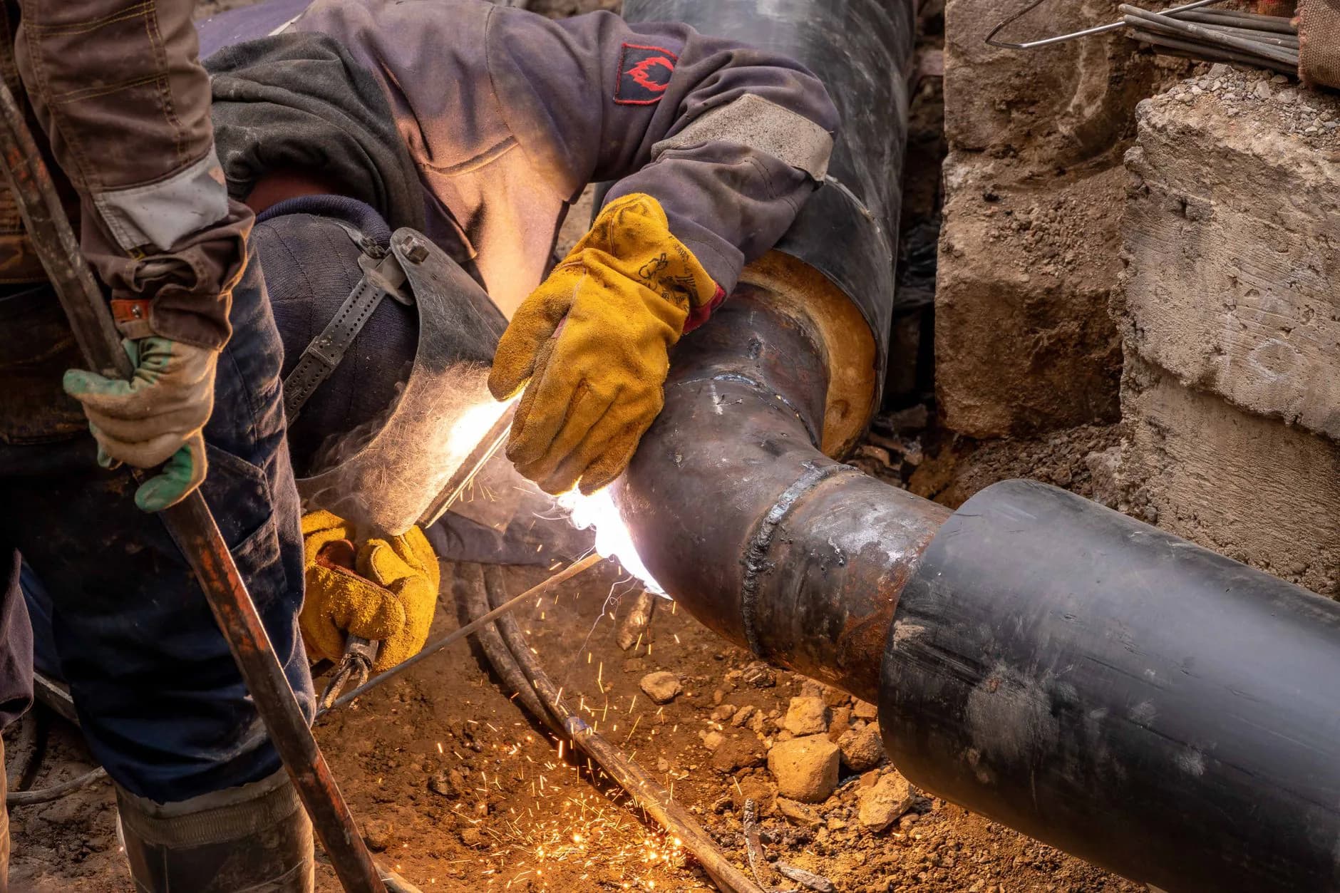 A plumber heating a copper fitting with a propane flame to solder a joint